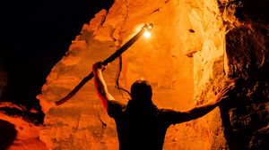 Preview wallpaper man, silhouette, fire, rocks