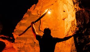 Preview wallpaper man, silhouette, fire, rocks