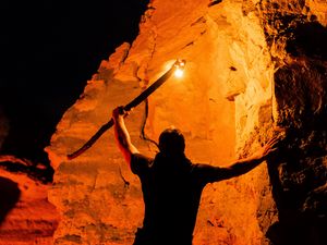 Preview wallpaper man, silhouette, fire, rocks