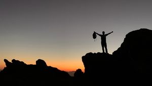 Preview wallpaper man, silhouette, freedom, loneliness, rocks, sunset