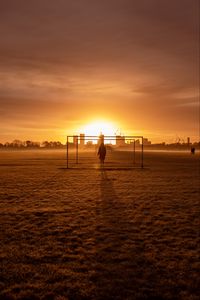 Preview wallpaper man, silhouette, gate, buildings, sunset