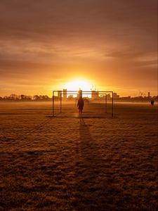 Preview wallpaper man, silhouette, gate, buildings, sunset