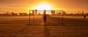 Preview wallpaper man, silhouette, gate, buildings, sunset