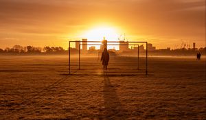 Preview wallpaper man, silhouette, gate, buildings, sunset