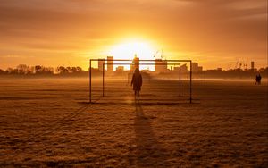 Preview wallpaper man, silhouette, gate, buildings, sunset