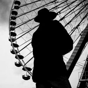 Preview wallpaper man, silhouette, hat, ferris wheel, alone, black and white