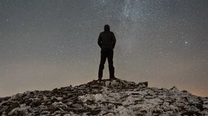 Preview wallpaper man, silhouette, hill, peak, starry sky