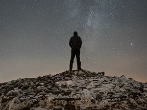 Preview wallpaper man, silhouette, hill, peak, starry sky