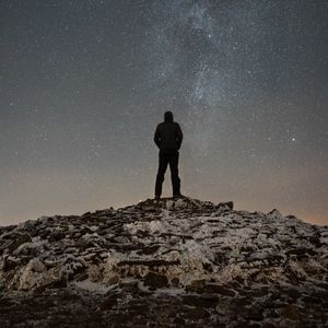 Preview wallpaper man, silhouette, hill, peak, starry sky