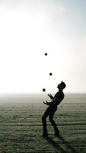 Preview wallpaper man, silhouette, juggling, field, fog
