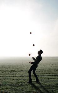 Preview wallpaper man, silhouette, juggling, field, fog