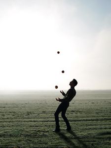 Preview wallpaper man, silhouette, juggling, field, fog