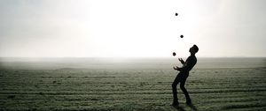 Preview wallpaper man, silhouette, juggling, field, fog