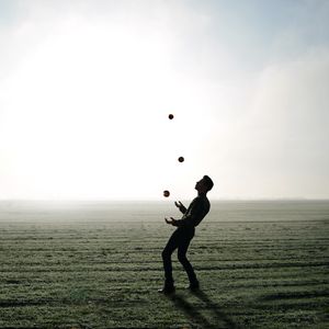 Preview wallpaper man, silhouette, juggling, field, fog