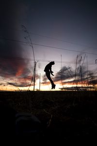 Preview wallpaper man, silhouette, jump, sunset, grass