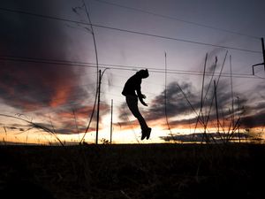 Preview wallpaper man, silhouette, jump, sunset, grass