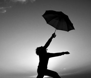 Preview wallpaper man, silhouette, jump, umbrella, black and white