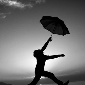 Preview wallpaper man, silhouette, jump, umbrella, black and white