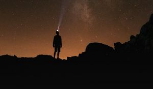 Preview wallpaper man, silhouette, night, flashlight, starry sky, dark