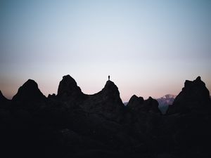 Preview wallpaper man, silhouette, rocks, outlines, dusk, dark