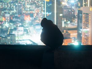 Preview wallpaper man, silhouette, roof, city, lights, dark