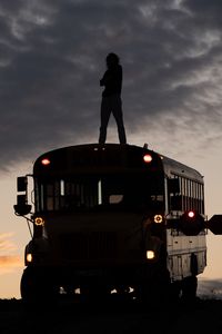 Preview wallpaper man, silhouette, triumph, alone, bus, sunset