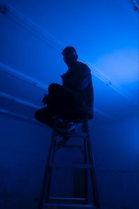 Preview wallpaper man, stepladder, dark, neon, blue