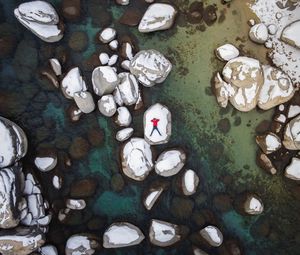 Preview wallpaper man, stones, rocks, snow, aerial view