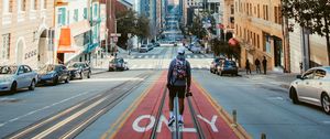Preview wallpaper man, street, city, road, buildings, cars