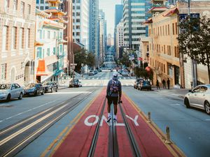 Preview wallpaper man, street, city, road, buildings, cars