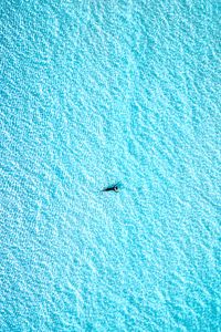 Preview wallpaper man, water, glare, wavy, aerial view