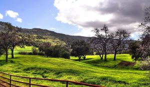 Preview wallpaper meadows, plain, fence, green, trees, clouds, mountains, valley, gray