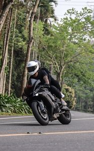 Preview wallpaper motorcycle, black, motorcyclist, speed, road, trees