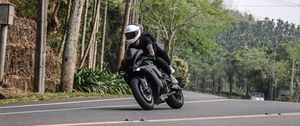 Preview wallpaper motorcycle, black, motorcyclist, speed, road, trees