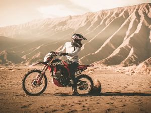 Preview wallpaper motorcycle, cross, motorcyclist, mountains, off-road, sand, helmet