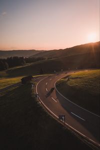 Preview wallpaper motorcycle, motorcyclist, road, hill, rays