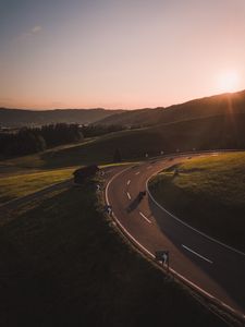 Preview wallpaper motorcycle, motorcyclist, road, hill, rays