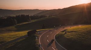 Preview wallpaper motorcycle, motorcyclist, road, hill, rays