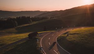 Preview wallpaper motorcycle, motorcyclist, road, hill, rays