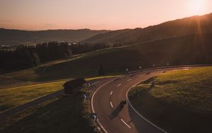 Preview wallpaper motorcycle, motorcyclist, road, hill, rays