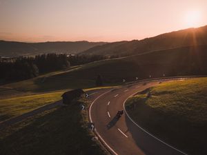 Preview wallpaper motorcycle, motorcyclist, road, hill, rays