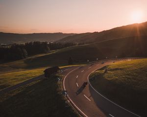 Preview wallpaper motorcycle, motorcyclist, road, hill, rays