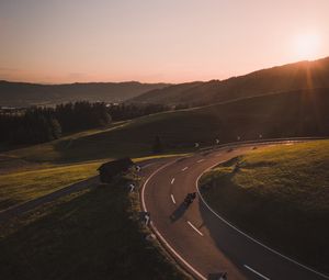 Preview wallpaper motorcycle, motorcyclist, road, hill, rays