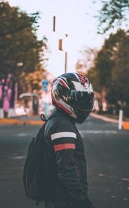 Preview wallpaper motorcyclist, helmet, jacket, backpack, blur