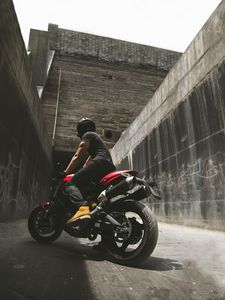 Preview wallpaper motorcyclist, motorcycle, helmet, wall, concrete