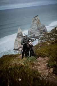 Preview wallpaper motorcyclist, motorcycle, helmet, rocks