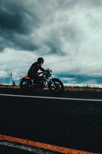 Preview wallpaper motorcyclist, road, marking, asphalt, helmet, clouds, overcast