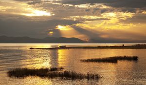 Preview wallpaper mountain, lake, boat, sunset, gold