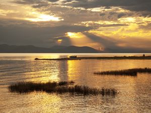 Preview wallpaper mountain, lake, boat, sunset, gold