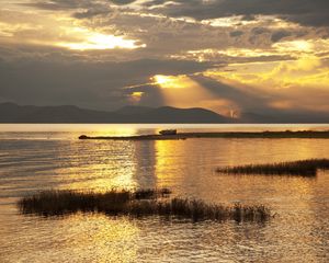 Preview wallpaper mountain, lake, boat, sunset, gold